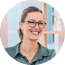 Smiling woman with glasses in a professional setting, representing EJN Financial's commitment to client-focused service and expertise in real estate financing.