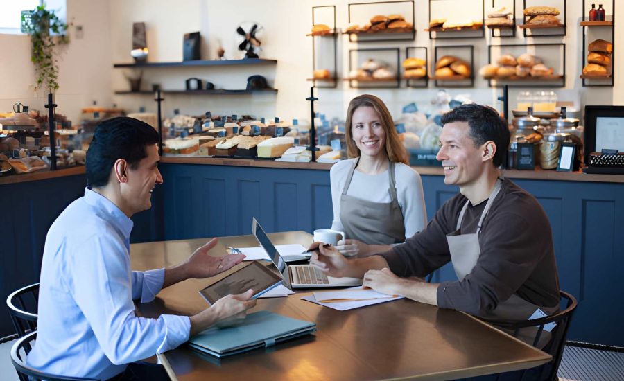 Bakery owners discussing financing—Commercial loan Florida consultation with laptops and business documents
