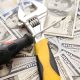 Fix and flip loans near me—wrench and screwdriver placed on U.S. $100 bills symbolizing repair costs and profits.