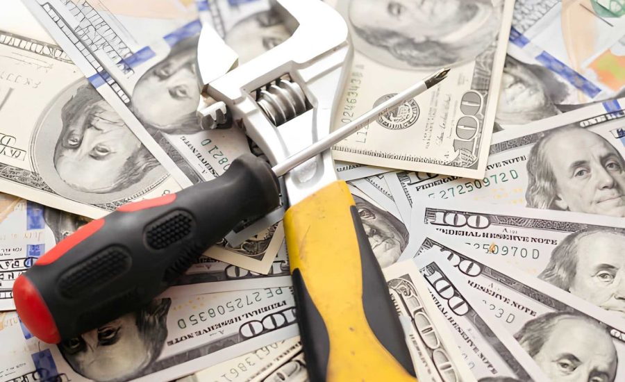 Fix and flip loans near me—wrench and screwdriver placed on U.S. $100 bills symbolizing repair costs and profits.